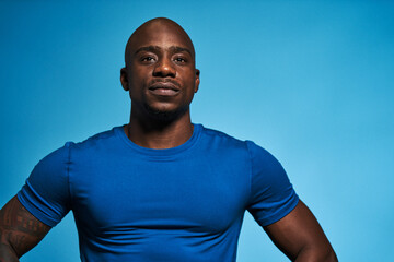 Portrait of athletic man in studio on blue background