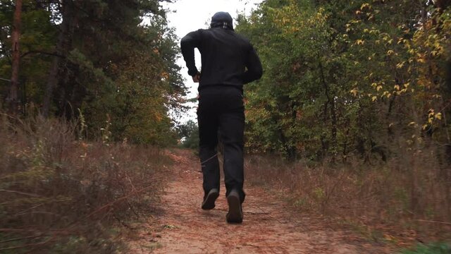 Men's legs are running. earth flies out from under your feet. man is running through the forest, close-up sneakers. Concept sports, jogging, running. sportsman goes sports and runs summer park. Slow