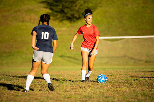 Female soccer player running by defender