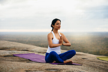 Indian woman breathing and doing meditation at park
