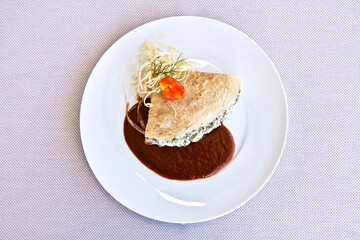 
platillo de crepes o crepas de huazontle con queso cabra y salsa de chile mulato