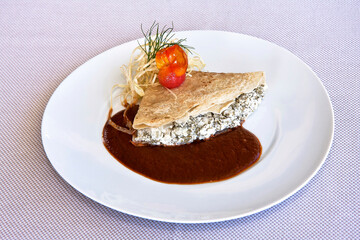 
platillo de crepes o crepas de huazontle con queso cabra y salsa de chile mulato