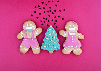 Decorations for the Christmas tree two gingerbread men with a mask on their face and a Christmas tree