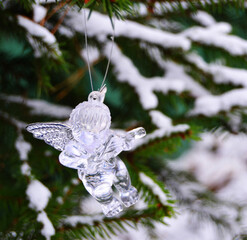 Crystal figure of an angel on a Christmas tree in the snow