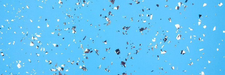 Festive blue background banner with holographic flying silver sparkles for your project. Holiday backdrop with copyspace. Birthday party, Christmas or New Year celebration concept