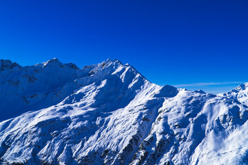 Naklejka premium Magical blue Austrian Alps panorama - background image of snowy mountains and peaks near Zürs, Austria