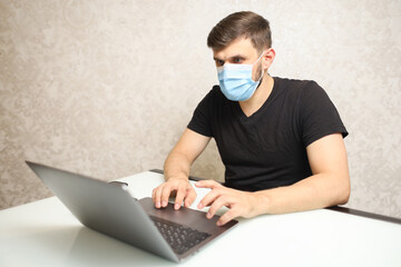 a man in a medical mask works at a computer