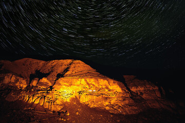 Starry night in famous tourist destination in Georgia-Illiuminated Vardzia cave city. Romantic evening in wilderness under the stars.