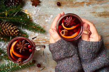 Woman hands hold cup of hot mulled wine