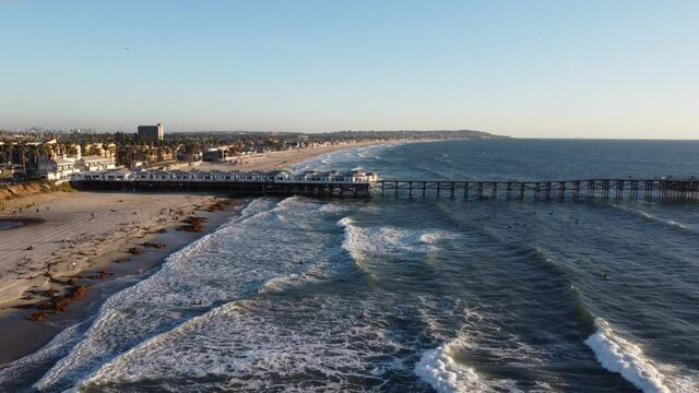 Aerial over surfers at Crystal Pier, San Diego, California.