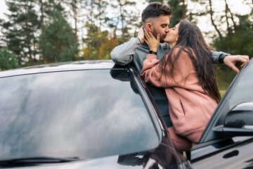 Beautiful couple stands at the car door and kissing