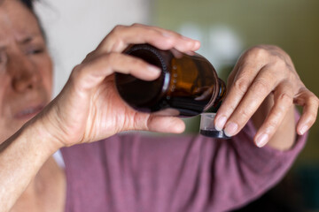 woman hands holding a bottle of cough syrup