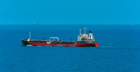 A small, old tanker ship at sea approaching the Singapore Straits in Asia in summertime