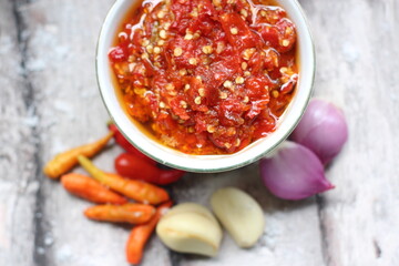 Sambal Bawang Or Spicy Onion Sauce with ingredients, Onion, Red Chilies, garlic, and salt. 