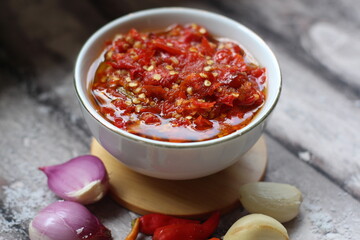 Sambal Bawang Or Spicy Onion Sauce with ingredients, Onion, Red Chilies, garlic, and salt. 