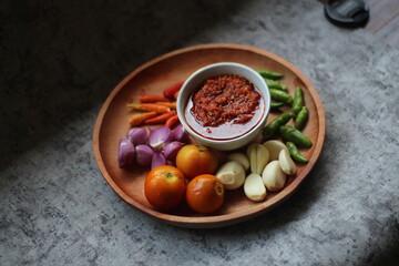 Indonesian traditional extra spicy chili sauce with ingredients, chilies, onions, garlic, salt, and tomatoes