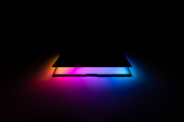 Opened MacBook illuminated with gradient view front