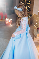 Fototapeta premium Little cute happy adorable girl in elegant fashion dress in christmas decorations. Christmas holidays, celebaration concept