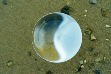 Photography of clear crystal ball. Yellow sand as background. Miracle view. Concepts of beauty of...