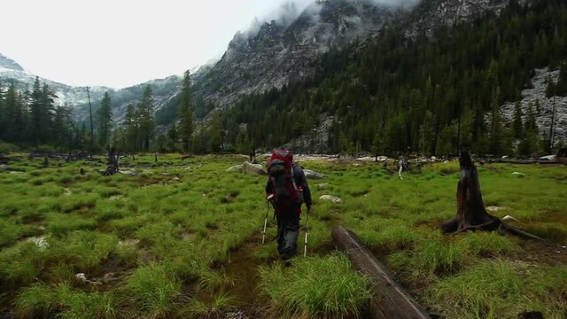 Tracking shot, backpacker hikes through field in The Enchantments