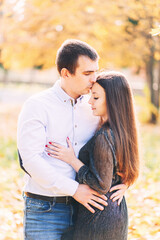 Cute loving couple hugging in the park in autumn