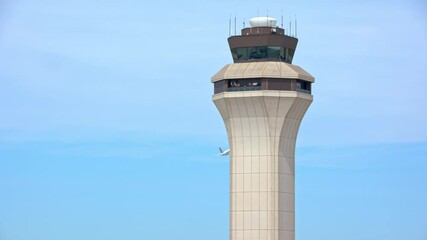 Generic Airport Air Traffic Control Tower with Departing Commercial Passenger Jet Airliner Taking Off past the ATC Communications Tower Flying into a Blue Sky on a Sunny Day
