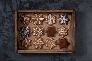 Collection of various gingerbread cookies in a box on wooden background