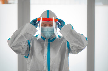 Fototapeta na wymiar Medical staff member with mask, rubber gloves and protective equipment in covid testing center