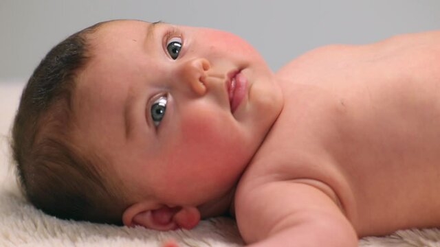 Caucasian baby girl laying on carpet