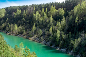 Fototapeta na wymiar green river flows at the bottom of hilly mountains
