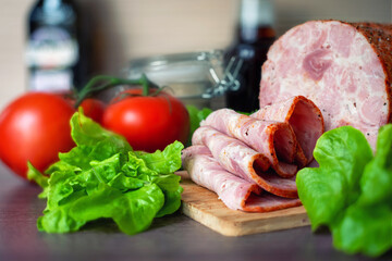 Home-made ham meat on a wooden board, background.