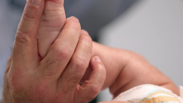 Grandfather playing with feet of granddaughter