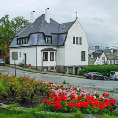 Fototapeta na wymiar Tidy flower bed near the cosy house in Norway