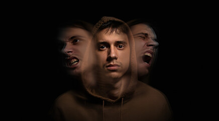 Art portrait on the topic of self-isolation. Split personality. Young guy on a dark background....