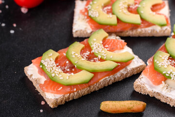 Delicious fresh sandwich with red fish, butter, bread and avocado