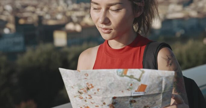 Profile of brunette exploring romantic Florence during summer vacation. Portrait of excited female tourist looking on city map standing at the viewpoint in the background of Santa Maria del Fiore .