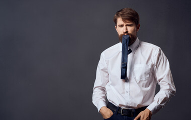 Man in suit aggression emotions model tie in teeth gray background Copy Space