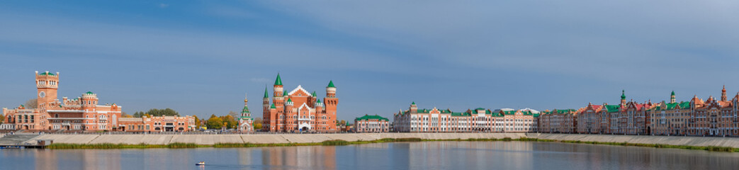Fototapeta na wymiar panorama of the castle and many red brick houses near the water blue sky