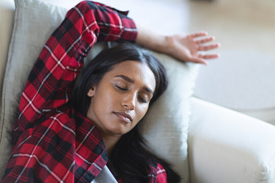 Mixed race woman sleeping on a couch at home