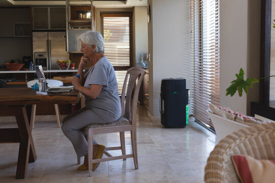 Senior caucasian woman having video consultation using laptop holding medication