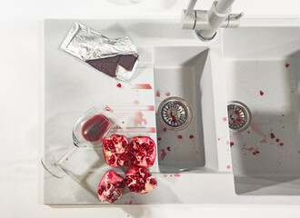 White quartz kitchen sink with blots from spilled red wine and pomegranate. Home routines