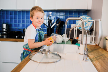 a boy helps his parents wash dishes.