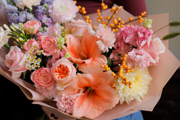 Colorful flowers assorted bouquet in bright paper. Holiday celebration concept. Bouquet of beautiful flowers in hands. Colorful flowers bouquet wrapped in paper