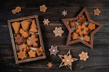 Collection of various gingerbread cookies in a star shaped box on wooden background