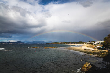 Bigo Spain Vigo Praia do Vao beach water waves blue water sky clouds rainbow hills mountains Playa de Calzoa Punta elena Enseada de Samil