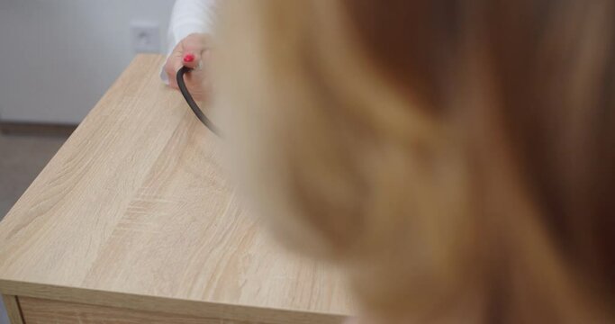 Close up shot. Caucasian female healthcare professional hands measuring blood pressure of patient with medical manometer while sitting in clinic in room at doctor appointment. Medical concept