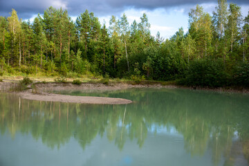 Fototapeta na wymiar Blue clear water lake with wood reflection