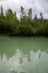 Blue clear water lake with wood reflection