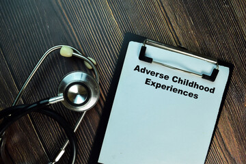 Adverse Childhood Experiences write on a paperwork isolated on Wooden Table. Medical or Healthcare...
