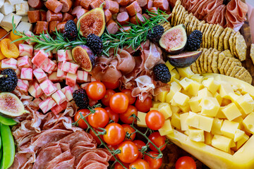Charcuterie board with variety or assortment of cheese, fruits and deli.